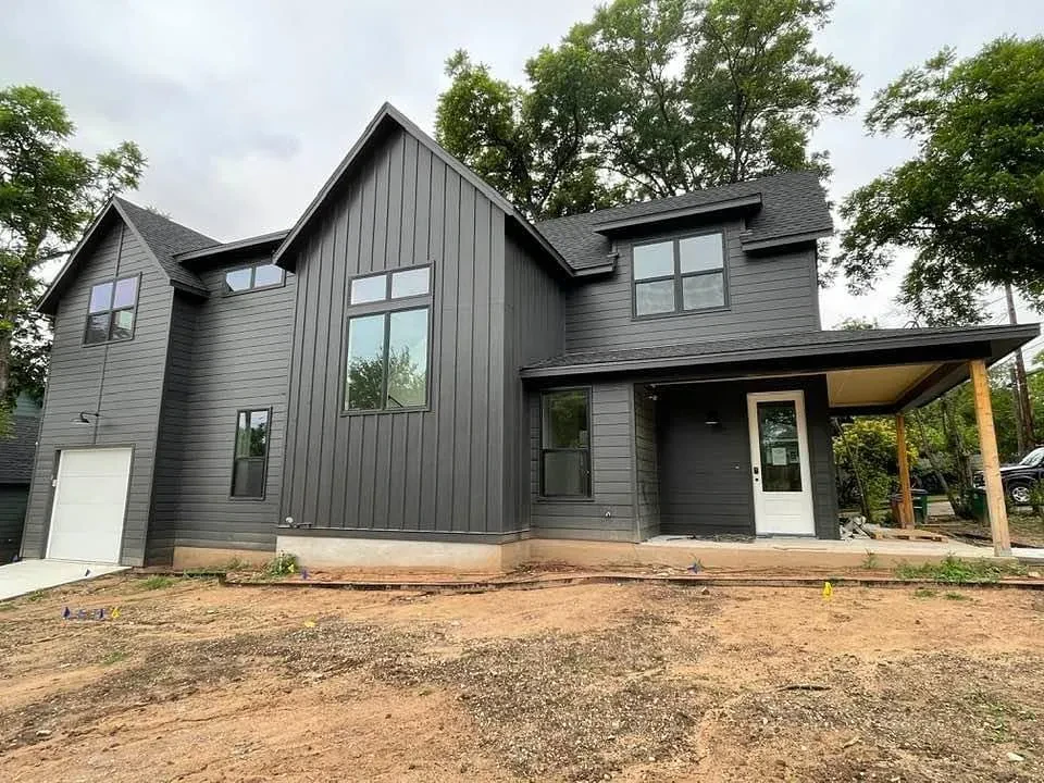 Two-story home with dark gray board-and-batten siding and a covered front porch