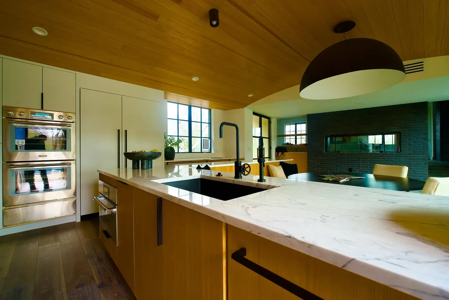Kitchen with marble countertops, light wood cabinets, and a wood plank ceiling
